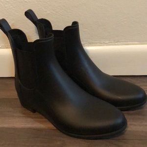 Black ankle high rain boots.